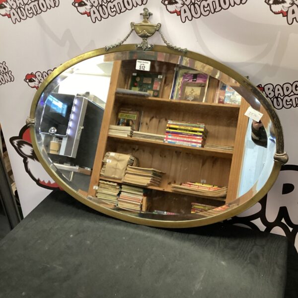Ornate Victorian oval mirror with brass surround.