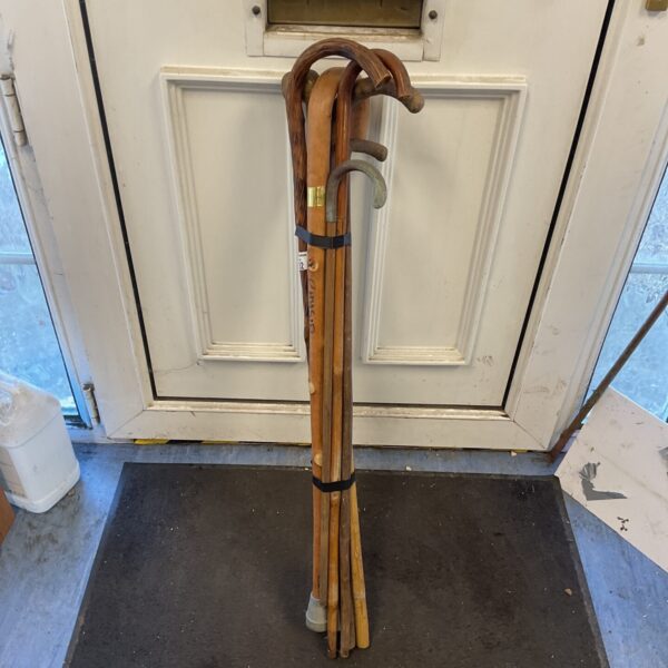 A lot of six antique walking sticks displayed together.