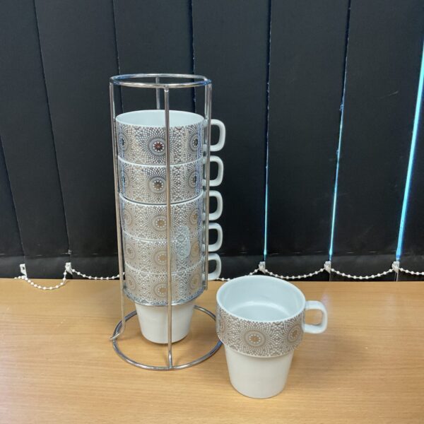 Vintage silver pattern mugs displayed on a chrome stand.