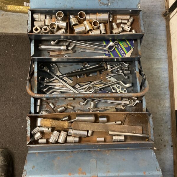 Open blue cantilever toolbox filled with vintage tools.
