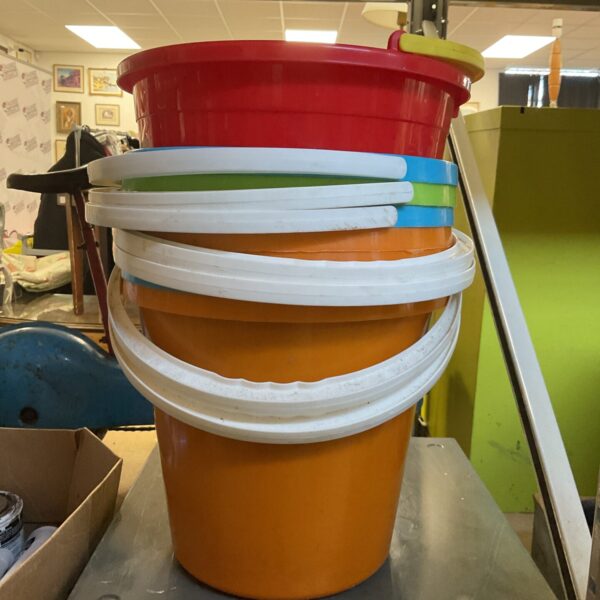 Assorted colourful plastic buckets stacked for storage.
