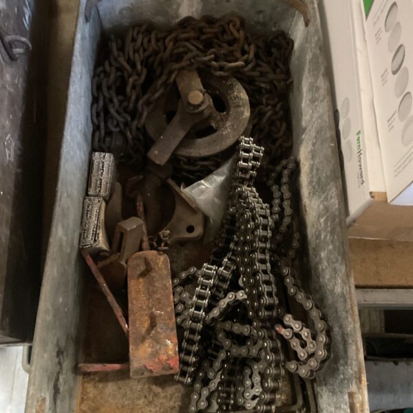 Galvanised chains and pulleys in a metal tray, workshop hardware.