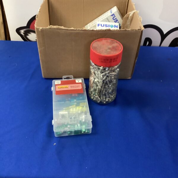 Tub of assorted car blade fuses for automotive electrical systems.