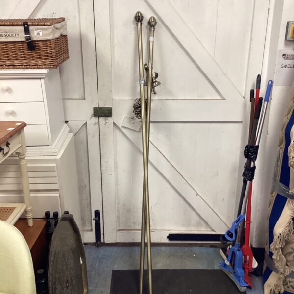 Vintage brass curtain railings displayed against a white door.