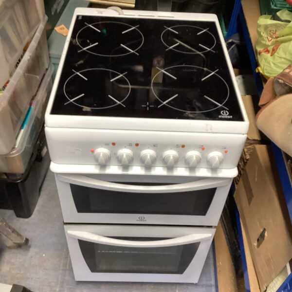 White Indesit electric cooker with ceramic hob and oven.