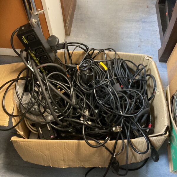 Assorted speaker cables and XLR leads in a cardboard box.