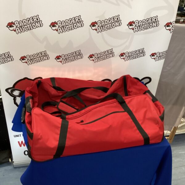 Large red holdall bag displayed on a blue background.
