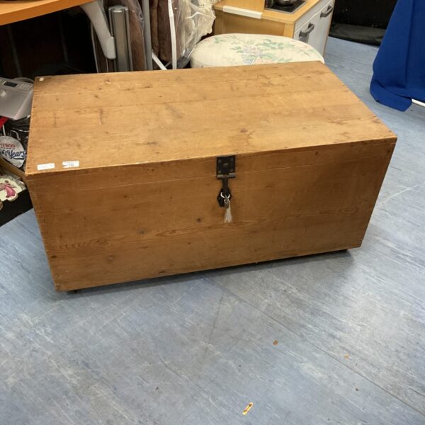 Large vintage wheeled wooden trunk for storage and display.