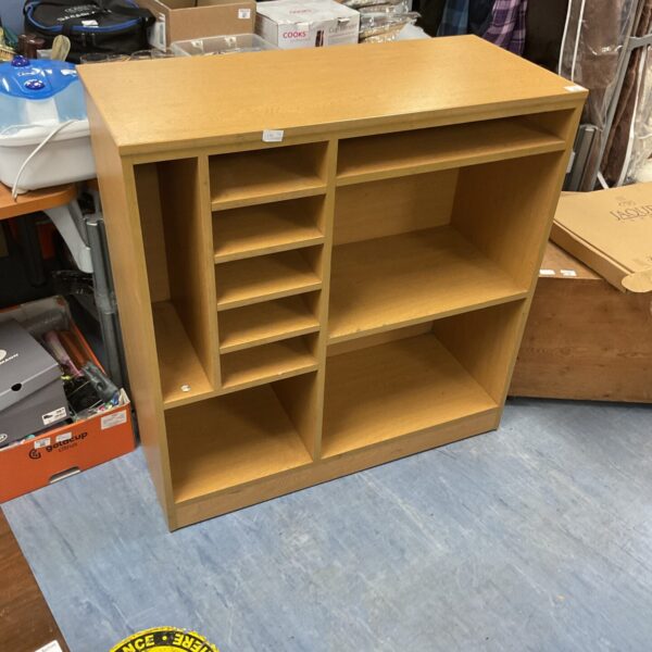 Wooden media unit with tiered shelving for home entertainment storage.
