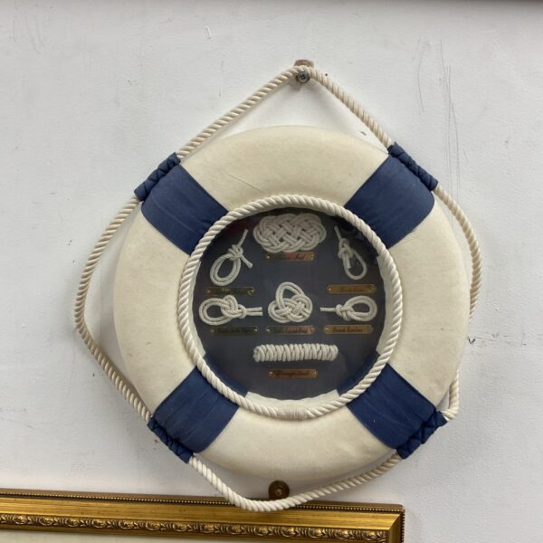 Vintage framed sailor's knot display with life ring.
