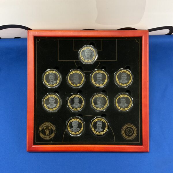 Vintage Manchester United medallion collection displayed in a case.