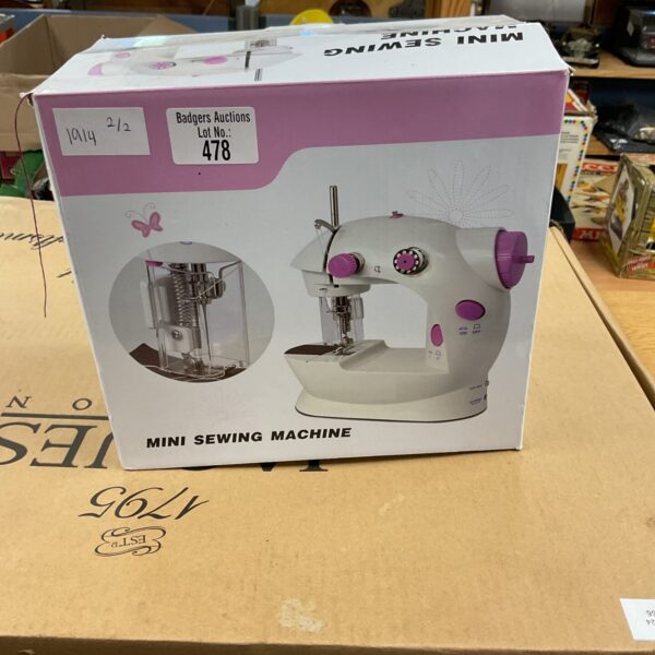 Pink mini sewing machine presented for auction.