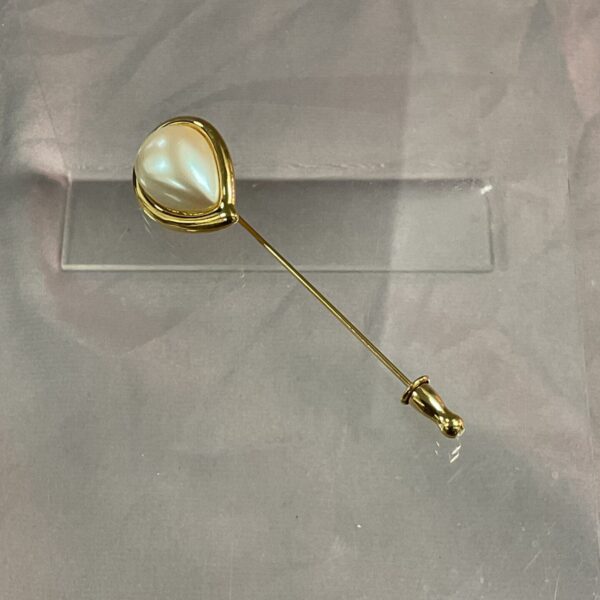 Close-up of vintage Monet pearl hat pin with faux pearl.