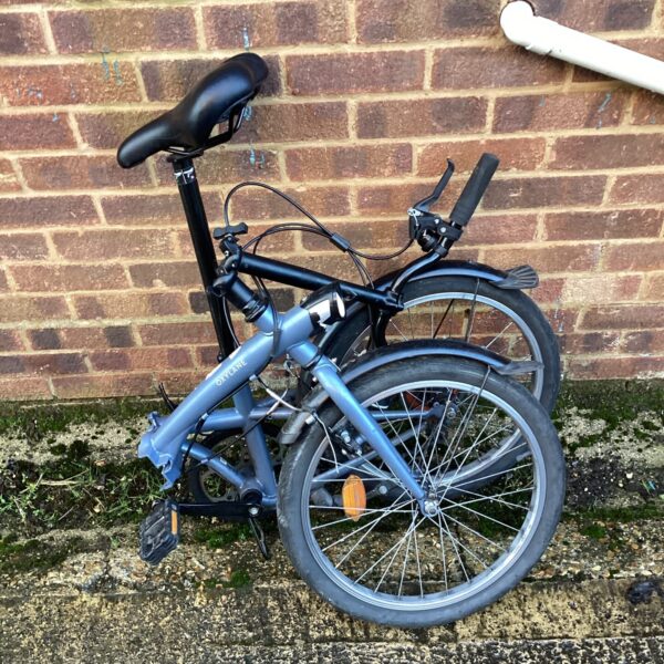Side view of a grey Oxylane folding bicycle.