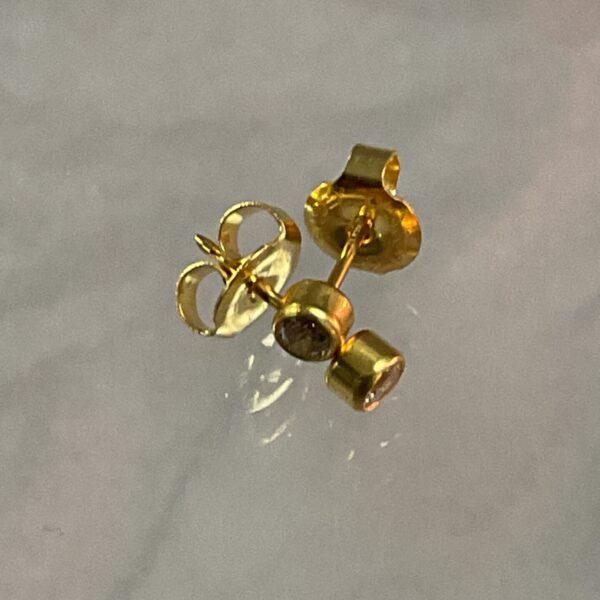 Close-up of 9ct gold white stone stud earrings.