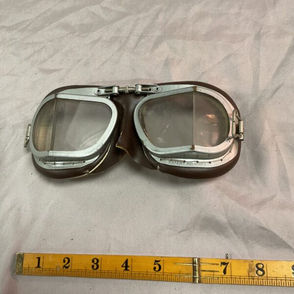 Vintage motorcycle goggles with leather strap and circular lenses.