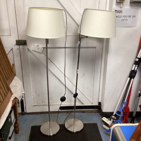 Pair of silver standard lamps with white shades for home lighting.