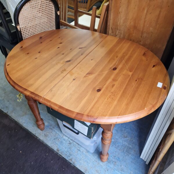 Round pine dining table with turned legs, rustic farmhouse style.