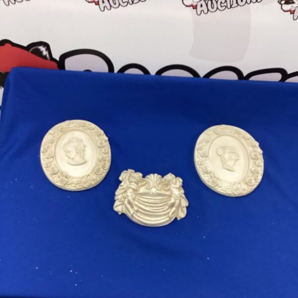 Vintage plaster medallion plaques with classical relief detailing.