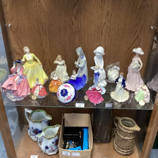 Collection of vintage Coalport lady figurines on display.
