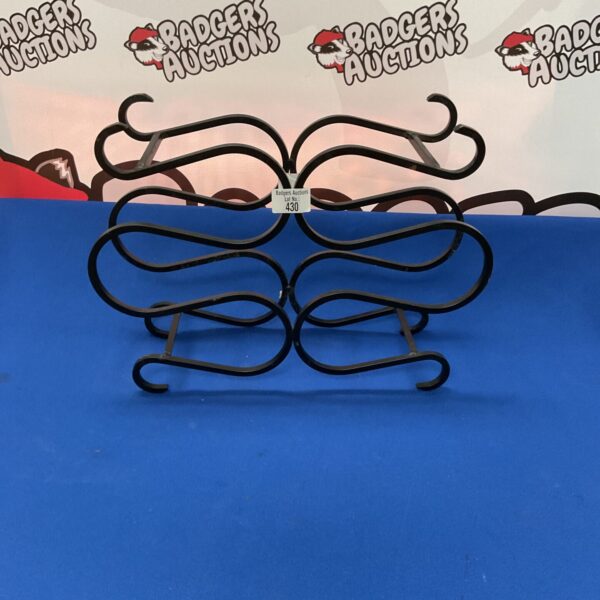 Wrought iron six bottle wine bottle holder for display.