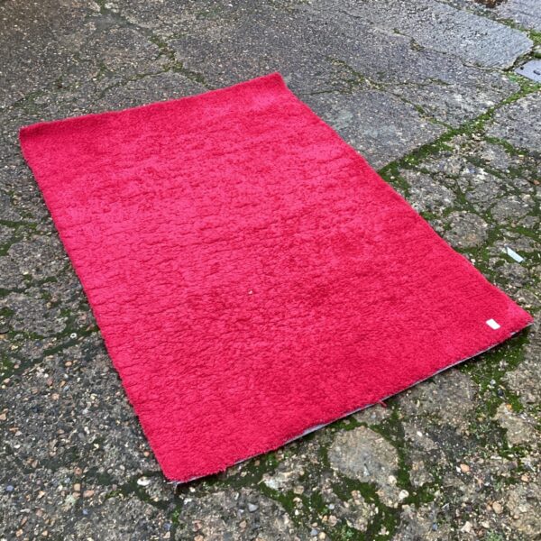 Vibrant red shag pile rug with a deep, soft texture.