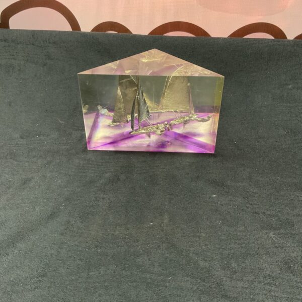 Clear resin block displaying a miniature sailing dinghy.