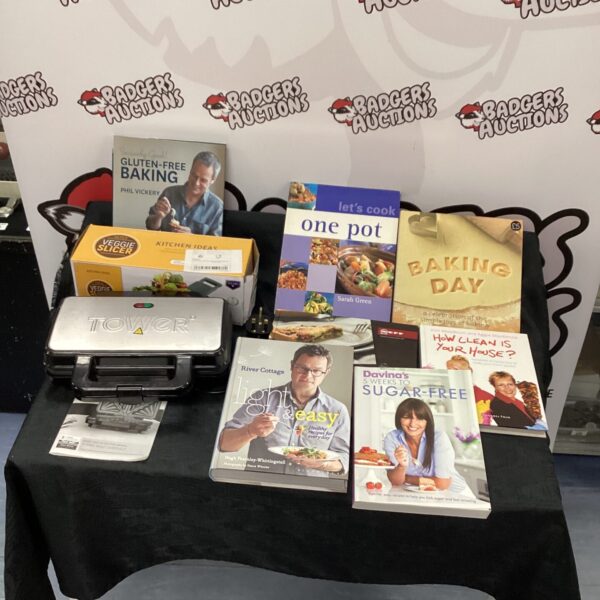 Cookbook collection with sandwich toaster and vegetable cutter on display.