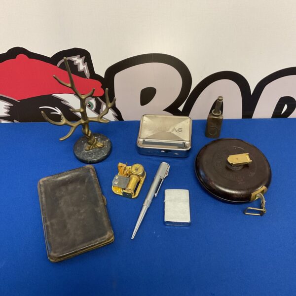 Vintage curios lot including music box, Zippo, and bakelite tape.