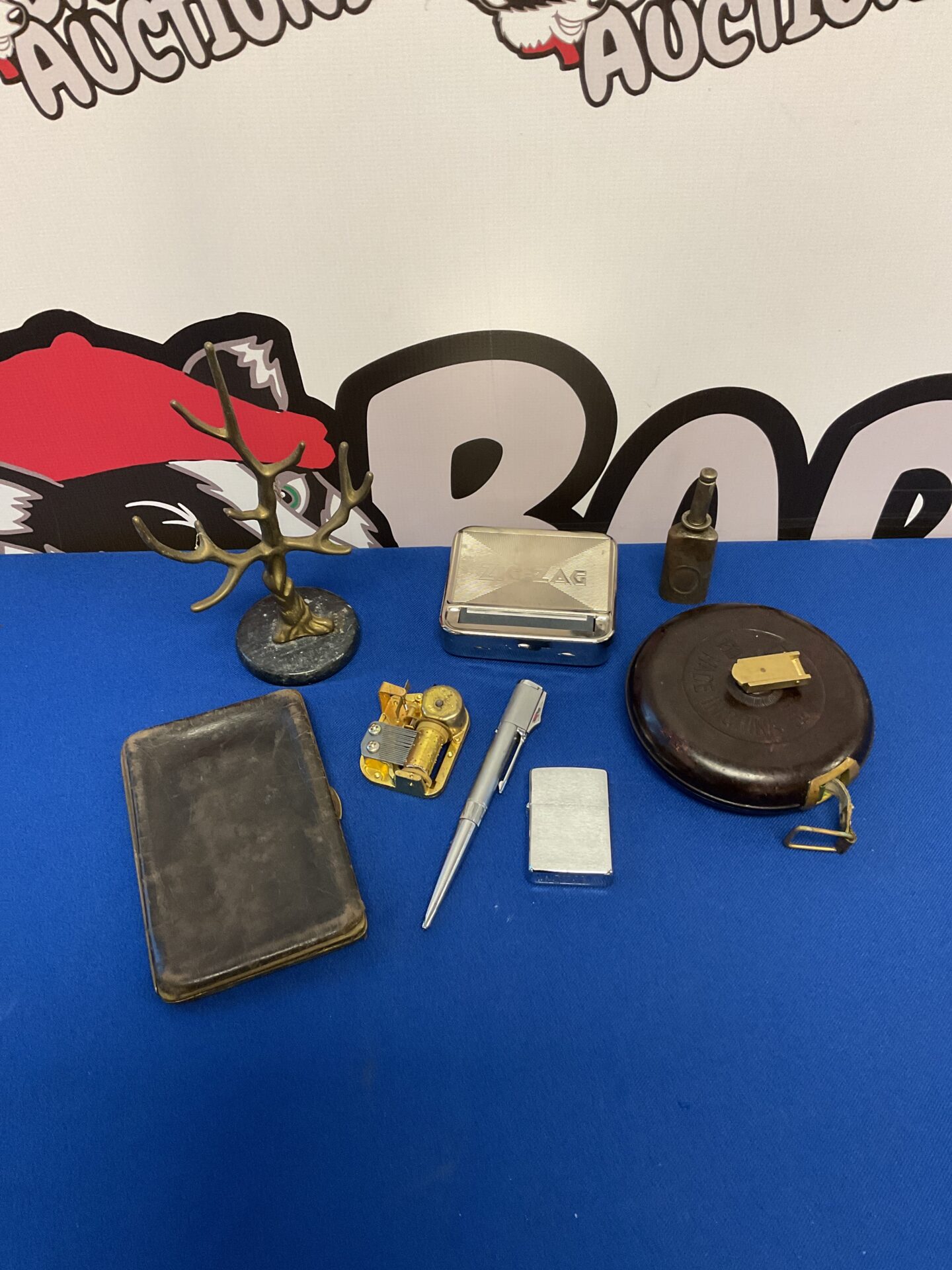 058 Selection of curios including music box mechanism, zippo lighter, gun oil can & bakelite measuring tape