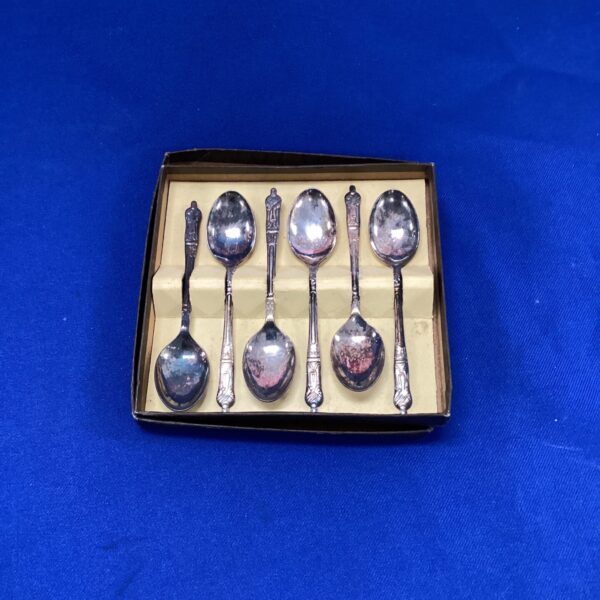 Antique silverplate apostle teaspoon set displayed on a dark surface.