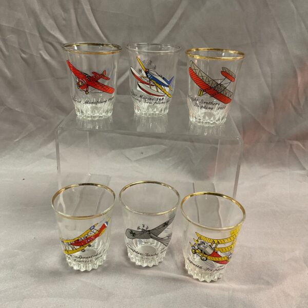 Set of six vintage WW1 aircraft shot glasses displayed together.