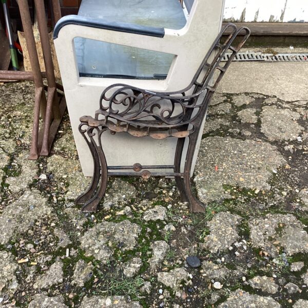 Antique wrought iron bench ends with scrolling foliage detail.
