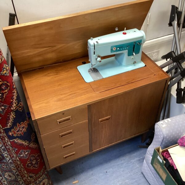 Vintage Singer sewing machine desk with integrated machine.