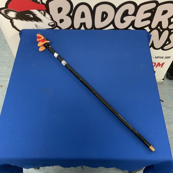 Decorative walking cane with lady figurine on blue backdrop.