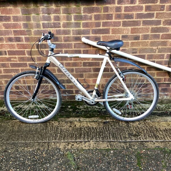 Silver mountain bike with front suspension, ideal for off-road cycling.