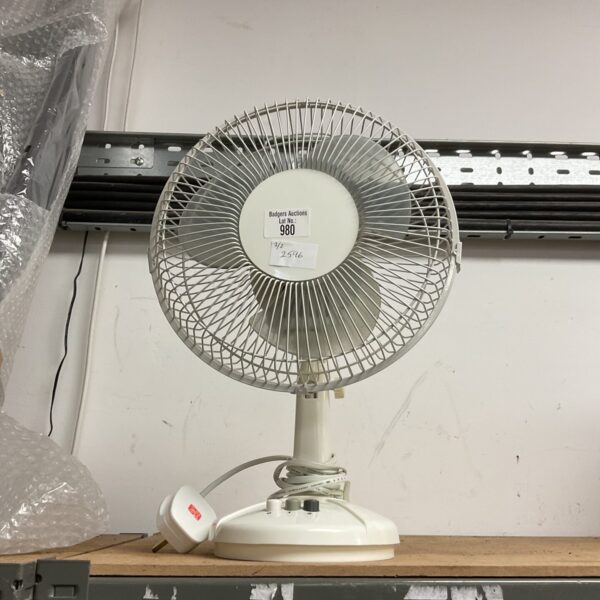 White vintage desk fan on a table.