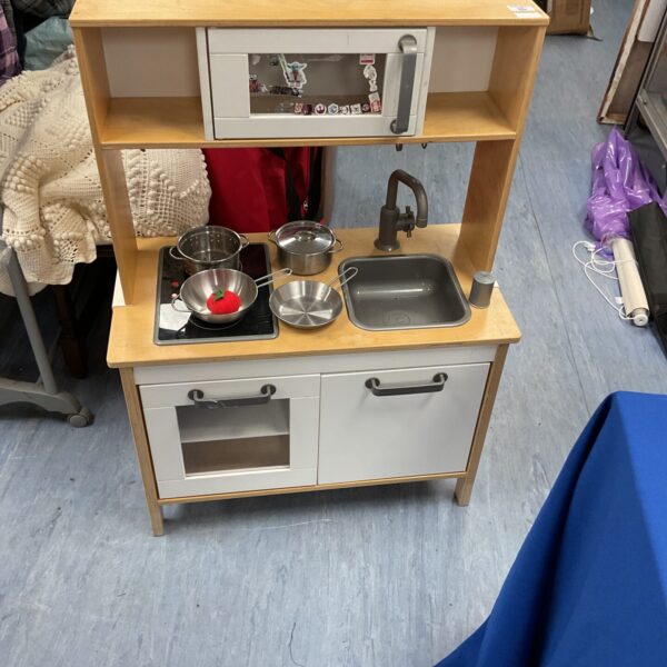 Wooden childrens play kitchen with accessories for imaginative role play.