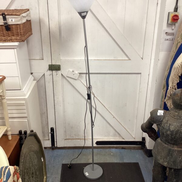 Silver uplighter floor lamp with white shade, modern interior lighting.