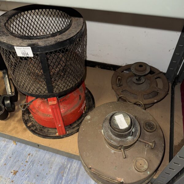 Vintage greenhouse heater with metal cage and burner.