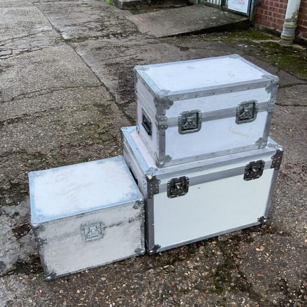 Stacked white aluminium transit boxes for equipment storage.