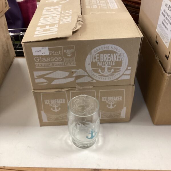 Lot of twenty-four Ice Breaker Pale Ale pint glasses stacked in a box.