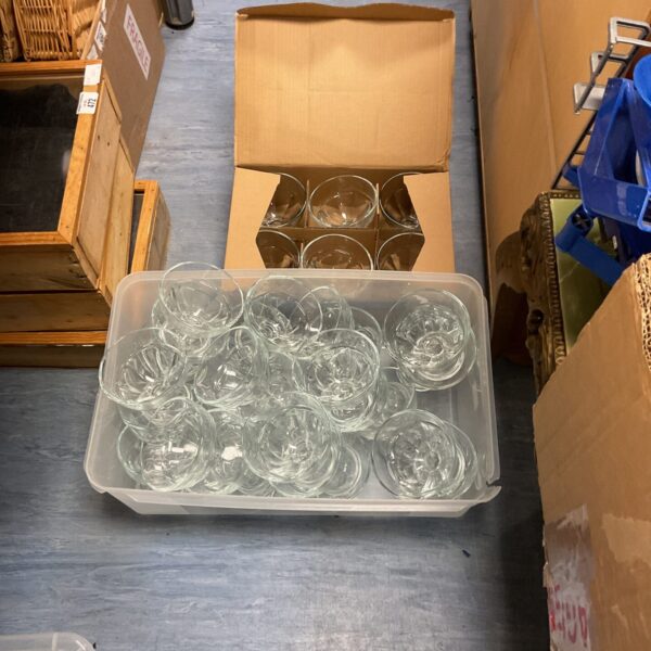 Clear glass serving dishes and bowls in a plastic container.