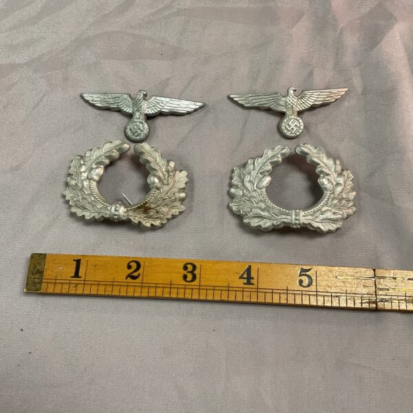 WWII German cap badges with eagle and swastika emblem.