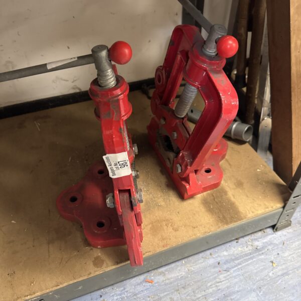 Pair of vintage metal pipe clamps for workshop or plumbing.