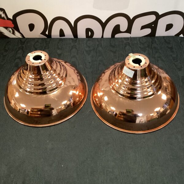 Two rose gold ceiling light shades with a flared design.