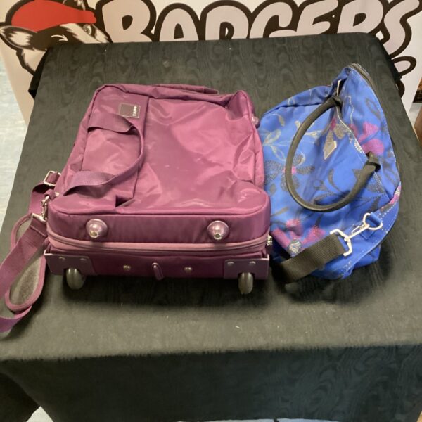 Purple Tripp luggage set with wheeled suitcase and handbag.