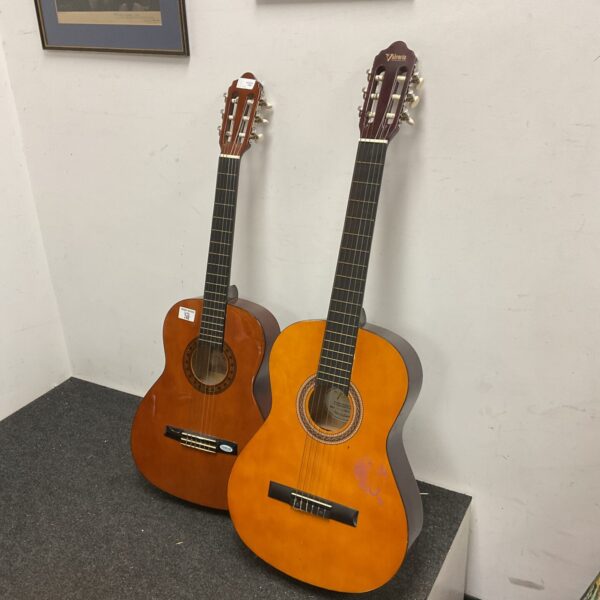 Pair of vintage Valencia acoustic guitars displayed indoors.