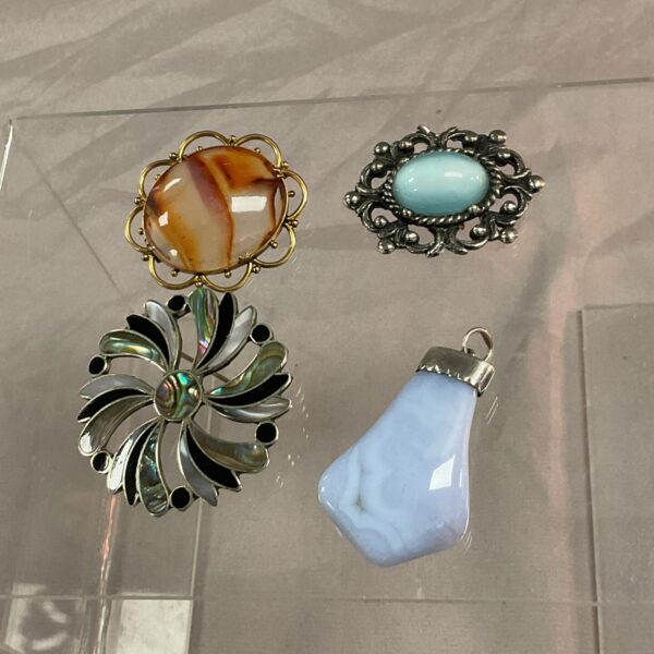 Vintage brooch and pendant lot with mother-of-pearl and amber details.