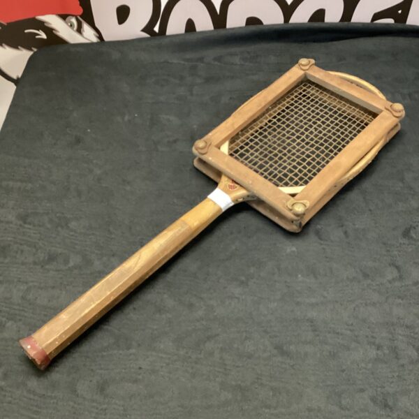 Vintage wooden tennis racket with woven strings, classic sports equipment.